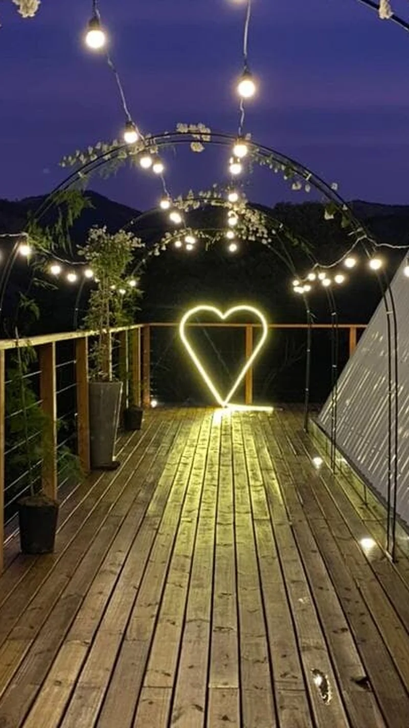 Deck da cabana à noite, com luzes e as estrelas