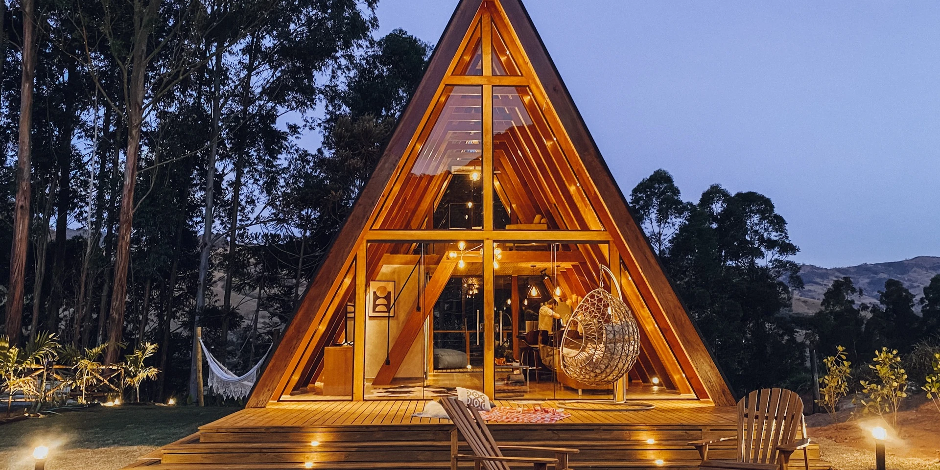 Cabana A-frame iluminada ao entardecer, na Serra da Mantiqueira